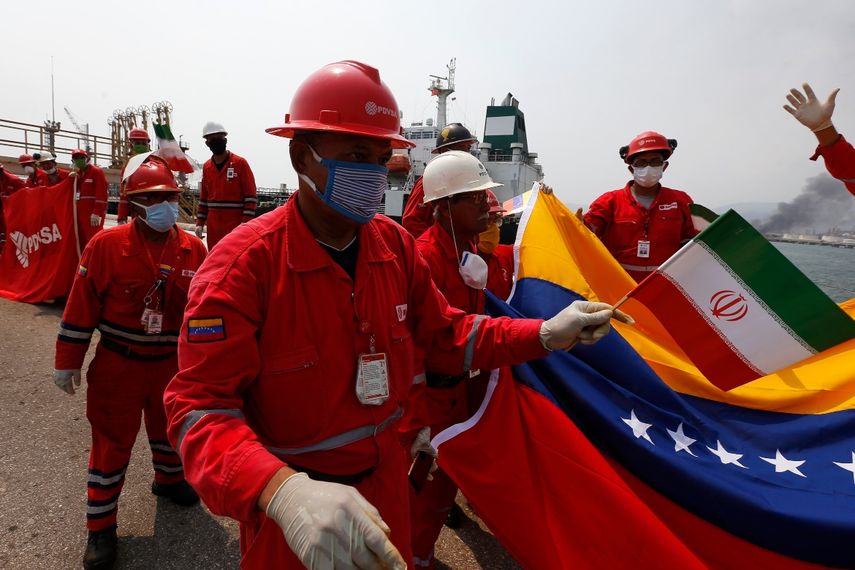 Un trabajador petrolero venezolano que sostiene una peque&ntilde;a bandera de Ir&aacute;n asiste a una ceremonia el lunes 25 de mayo de 2020 por la llegada del buque iran&iacute; Fortune, en la refiner&iacute;a El Palito cerca de Puerto Cabello, Venezuela
