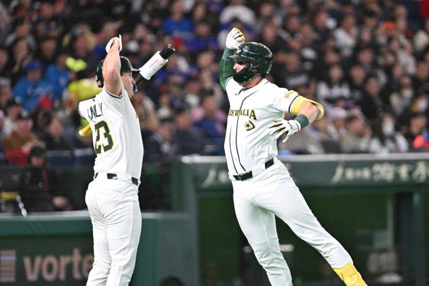 El australiano Robbie Perkins (der.) celebra su jonrón de dos carreras con su compañero Tim Kennelly (izq.) en la quinta entrada del partido de primera ronda del Grupo C del Clásico Mundial de Béisbol (CMB) entre Australia y Taiwán en el Tokyo Dome el 5 de marzo de 2026.&nbsp;