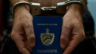 Un hombre sostiene un pasaporte de Cuba.&nbsp;