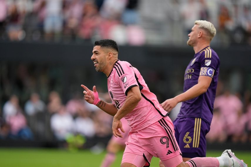 El delantero del Inter Miami Luis Suárez (9) pasa junto al defensor de la ciudad de Orlando Robin Jansson (6) mientras celebra después de anotar el segundo gol de su equipo durante la primera mitad de un partido de fútbol de la MLS, el sábado 2 de marzo de 2024, en Fort Lauderdale, Florida. 