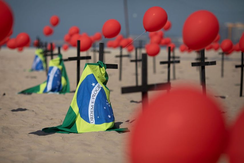 Cruces, globos rojos y la bandera de Brasil son colocados en la playa de Copacabana por el organismo no gubernamental R&iacute;o de Paz en honor a las v&iacute;ctimas de COVID-19, en R&iacute;o de Janeiro, Brasil, el s&aacute;bado 8 de agosto de 2020.&nbsp;
