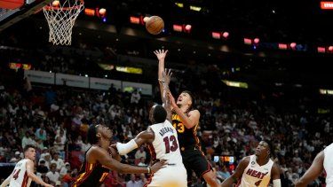 El escolta de los Atlanta Hawks, Bogdan Bogdanovic (13), pasa por encima de la defensa del centro del Heat de Miami, Bam Adebayo (13), durante la primera mitad de un partido de la NBA, el martes 11 de abril de 2023, en Miami.&nbsp;