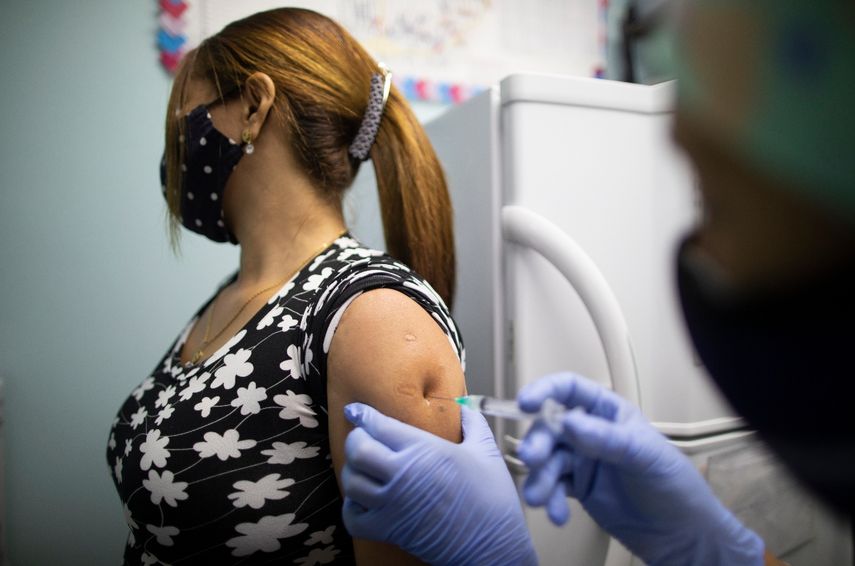 Una enfermera aplica una dosis de la vacuna de Sinopharm contra el coronavirus a una trabajadora del sector salud, en un centro del programa sanitario Barrio Adentro del régimen, en Caracas, Venezuela, el domingo 7 de marzo de 2021.