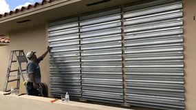 Un hombre protege las ventanas de su vivienda en Miami, ante la cercanía de un huracán.