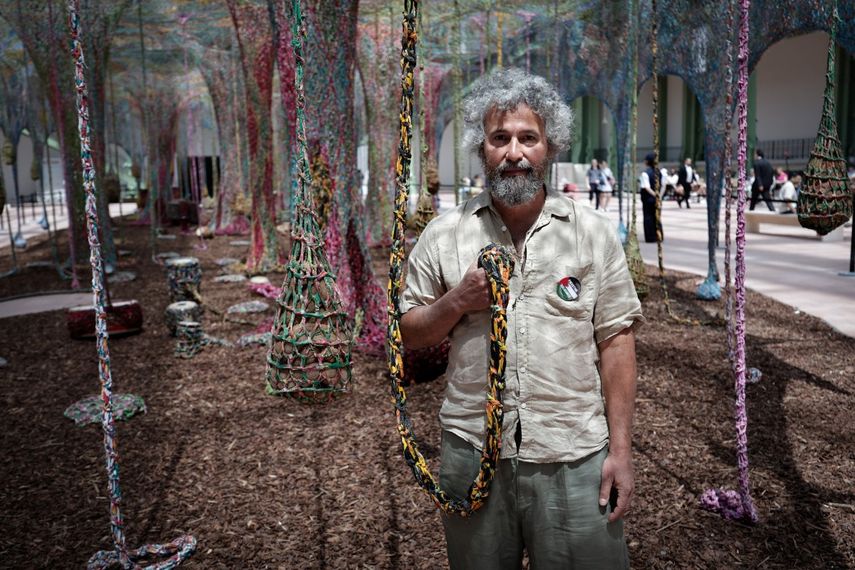 El artista brasileño Ernesto Neto posa para una fotografía junto a su instalación de arte llamada Nosso Barco Tambor Terra en el Grand Palais dete en París el 10 de junio de 2025.