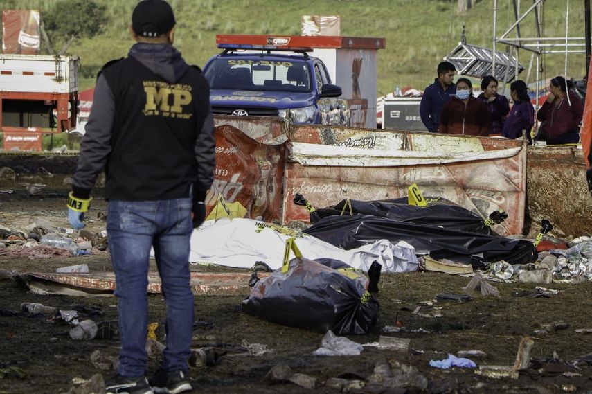 Un miembro del Ministerio Público se encuentra cerca de los cadáveres después de una estampida después de un concierto por el día de la independencia de Guatemala en Quetzaltenango, 200 km al oeste de la Ciudad de Guatemala, el 15 de septiembre de 2022.
