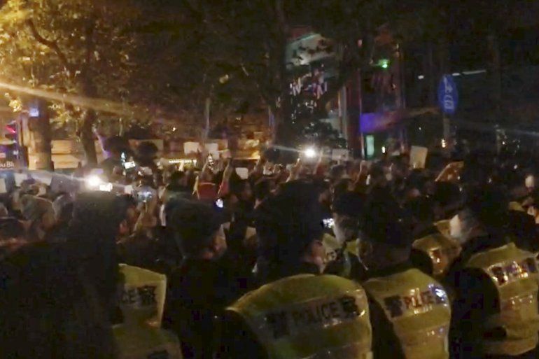 Imagen de un video obtenida por The Associated Press de la policía viendo a manifestantes en Shanghái el sábado, 26 de noviembre de 2022.  