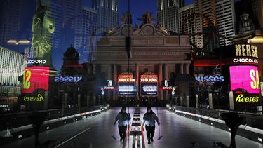 En imagen del 18 de abril de 2020, una trabajadora con cubrebocas limpia una acera entre casinos y otros negocios cerrados por el brote del nuevo coronavirus en Las Vegas.&nbsp;