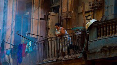 Una mujer asomada a un balcón en La Habana Vieja, Cuba. 