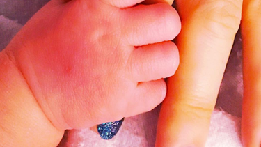 El hijo de Holly Madison sostiene el dedo de su madre.