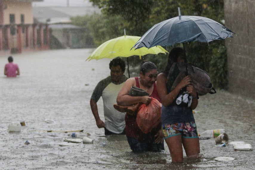 Residentes caminan por una carretera inundada con algunas pertenencias en Progreso Yoro, Honduras, el miércoles 4 de noviembre de 2020.