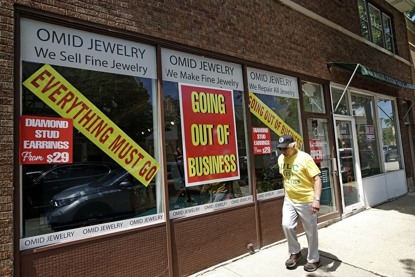 Un hombre camina frente a un negocio cerrado tras el impacto de la pandemia.