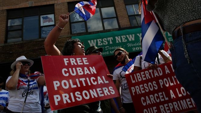 La gente sostiene carteles exigiendo la liberación de los presos políticos en Cuba durante una protesta en Union City, Nueva Jersey, el 18 de julio de 2021.