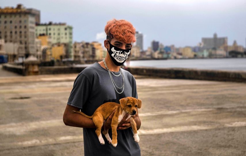 Poo Alejandro Padrun, 15 a&ntilde;os, usa una mascarilla como protecci&oacute;n contra el nuevo coronavirus mientras posa con su perro en el Malec&oacute;n de La Habana, Cuba, el mi&eacute;rcoles 22 de julio de 2020
