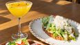 Un cóctel acompaña las preparaciones que llegan a la mesa para compartir.
