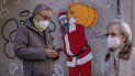 Un hombre y una mujer, con mascarillas FFP2 para frenar la propagación del coronavirus, delante de un mural que representa a Papá Noel, En Madrid, el 12 de enero de 2022. Un hombre y una mujer, con mascarillas FFP2 para frenar la propagación del coronavirus, delante de un mural que representa a Papá Noel, En Madrid, el 12 de enero de 2022.
