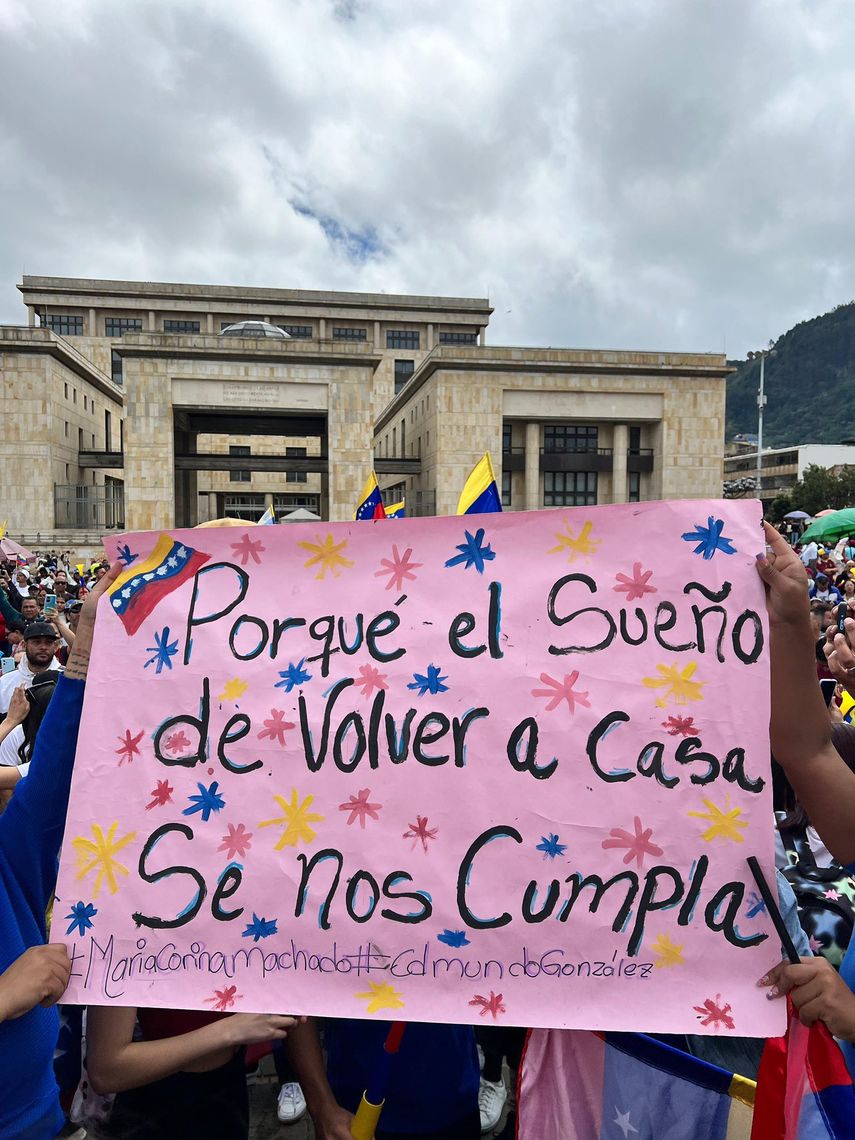 Venezolanos muestran pancarta durante acto de campaña de la oposición venezolana en Bogotá, Colombia.