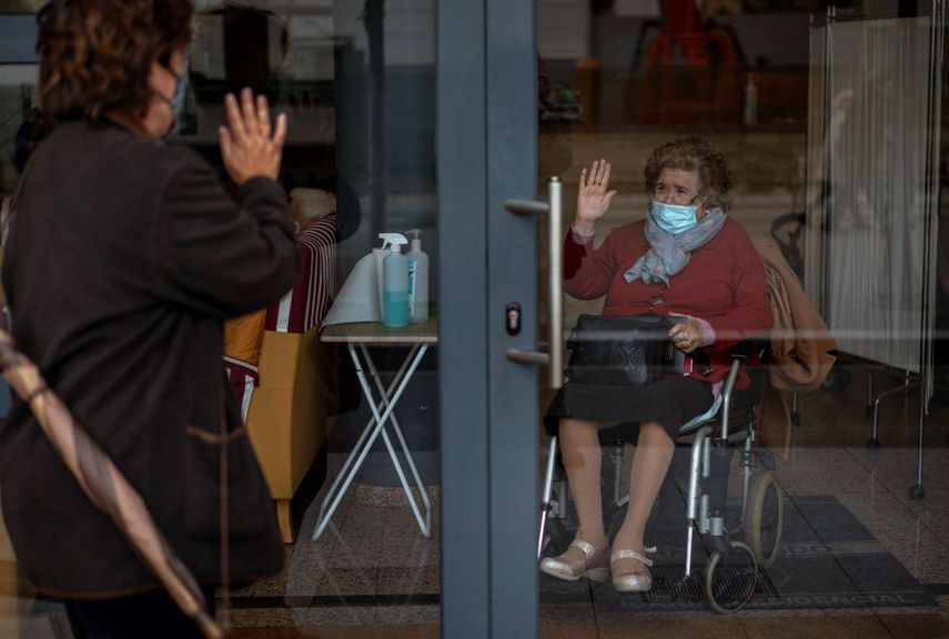 Angels Trepat, de 59 años, se despide de su madre, Angelina, de 91 años, tras visitarla en la residencia Icaria de Barcelona, el viernes 27 de noviembre de 2020. Los trabajadores de funerarias vuelven a verse sobrepasados por un brote de coronavirus en residencias y hospicios de toda Europa, que ha sumido a las autoridades y trabajadores de residencias en una carrera contrarreloj hasta que puedan comenzar las vacunaciones.&nbsp;