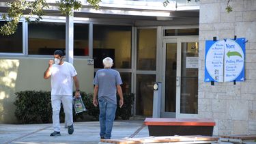 Uno entra a votar y otro sale tras depositar su voto, en la bibliteca&nbsp;de Shenandoah,