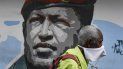 Un hombre que porta una mascarilla improvisada para protegerse del coronavirus camina el domingo 29 de marzo de 2020 junto a un mural del fallecido Hugo Chávez, en Caracas, Venezuela Un hombre que porta una mascarilla improvisada para protegerse del coronavirus camina el domingo 29 de marzo de 2020 junto a un mural del fallecido Hugo Chávez, en Caracas, Venezuela