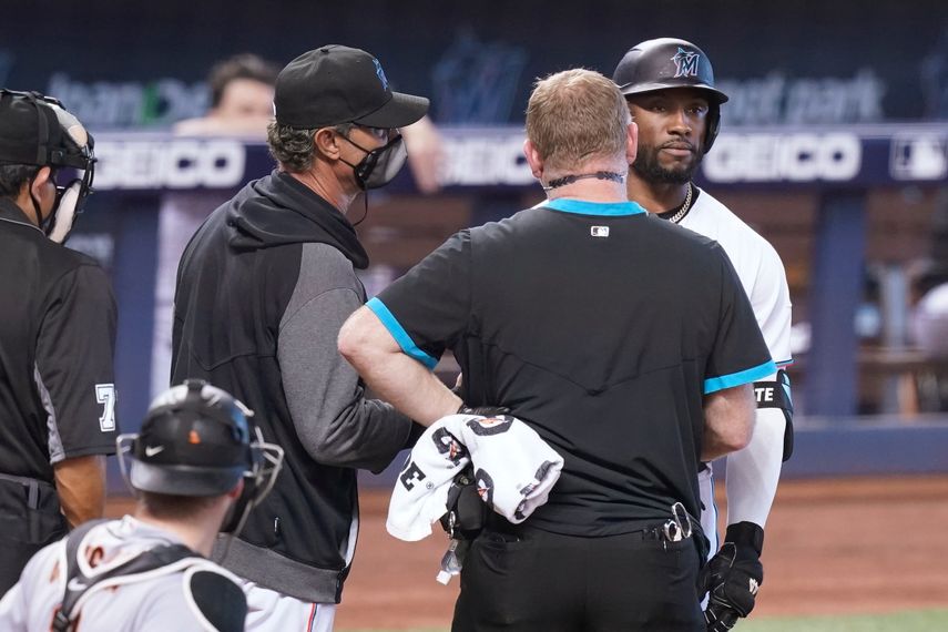 El mánager de los Marlins de Miami Don Mattingly y un entrenador hablan con el bateador Starling Marteantes de ayudarle a salir en el encuentro ante los Gigantes de San Francisco el domingo 18 de abril del 2021.&nbsp;