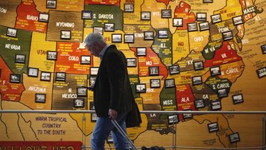 El esta foto del 18 de marzo del 2020, un viajero revisa su celular en la terminal principal del Aeropuerto Internacional de Denver, Colorado.