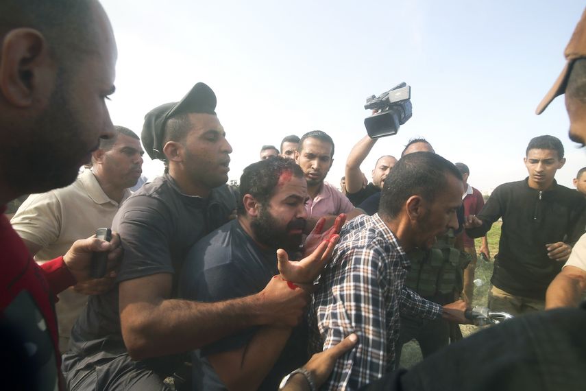 Palestinos transportan a un civil israelí capturado en el Kibbutz Kfar Azza, Israel, a la Franja de Gaza, sábado 7 de octubre de 2023. 