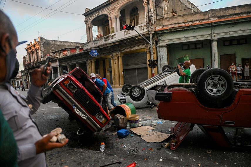 Los coches de la policía se ven volcados en la calle en el marco de una manifestación contra el presidente cubano Miguel Díaz-Canel en La Habana, el 11 de julio de 2021.