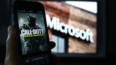 Una imagen de Call of Duty de Activision se muestra en un teléfono inteligente cerca de una fotografía del logotipo de Microsoft en esta foto tomada en Nueva York, el jueves 15 de junio de 2023.
