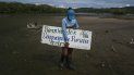Un miembro de la fundación ecológica Ecobrion sostiene un cartel que dice Bienvenidos a la laguna La Reina en el humedal costero del sector Valle Seco en Higuerote, estado Miranda, Venezuela, el 4 de octubre de 2022. 