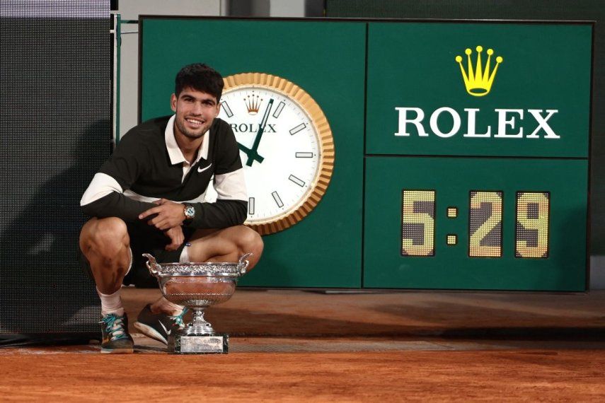 El español Carlos Alcaraz posa el trofeo junto al reloj que marca la duración del partido, el más largo para una final de Roland-Garros, después de ganar al italiano Jannik Sinner al final de su partido final individual masculino en el día 15 del torneo de tenis Roland-Garros en la cancha Philippe-Chatrier en el Complejo Roland-Garros en París el 8 de junio de 2025. El español Carlos Alcaraz posa el trofeo junto al reloj que marca la duración del partido, el más largo para una final de Roland-Garros, después de ganar al italiano Jannik Sinner al final de su partido final individual masculino en el día 15 del torneo de tenis Roland-Garros en la cancha Philippe-Chatrier en el Complejo Roland-Garros en París el 8 de junio de 2025.