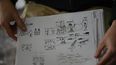 El ilustrador venezolano Lucas García Paris muestra bocetos del cómic El amparo mientras habla durante una entrevista con la AFP en su casa de Caracas, Venezuela, el 7 de diciembre de 2023.