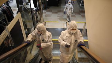 Trabajadores con equipo de protección rocían desinfectante como protección contra el nuevo coronavirus en unos grandes almacenes de Seúl, Corea del Sur, el lunes 2 de marzo de 2020.