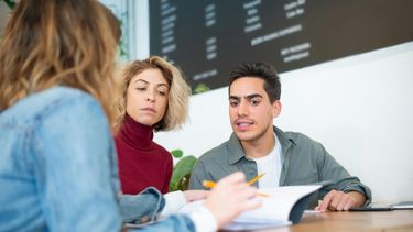 Tres personas hablan sobre negocios