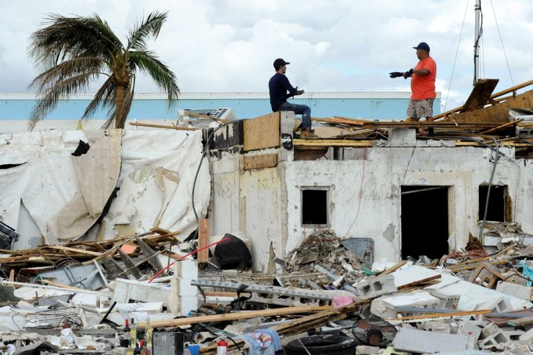 Dos personas trabajan encima de una construcción que resultó sumamente dañada por el huracán Ian, el domingo 9 de octubre de 2022, en Fort Myers Beach, Florida. 