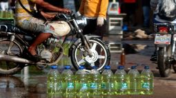 Decenas de envases pl&aacute;sticos llenos de gasolina inundan las calles de un empobrecido barrio de Maracaibo