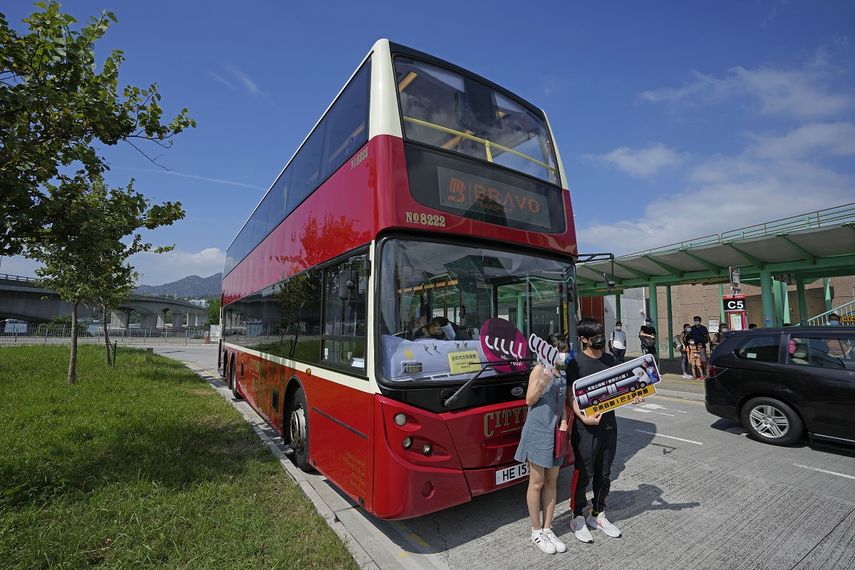 Pasajeros posan para una foro delante de un autobús antes de abordar, en Hong Kong, el sábado, 16 de octubre del 2021. Residentes insomnes pudieran encontrar alivio en un nuevo autobús en Hong Kong. El recorrido de 76 kilómetros (47 millas) y cinco horas en un bus de dos pisos alrededor del territorio busca atraer a personas que se quedan dormidas fácilmente en viajes largos. Fue inspirado por la tendencia de trabajadores cansados a dormirse en el transporte público.&nbsp;