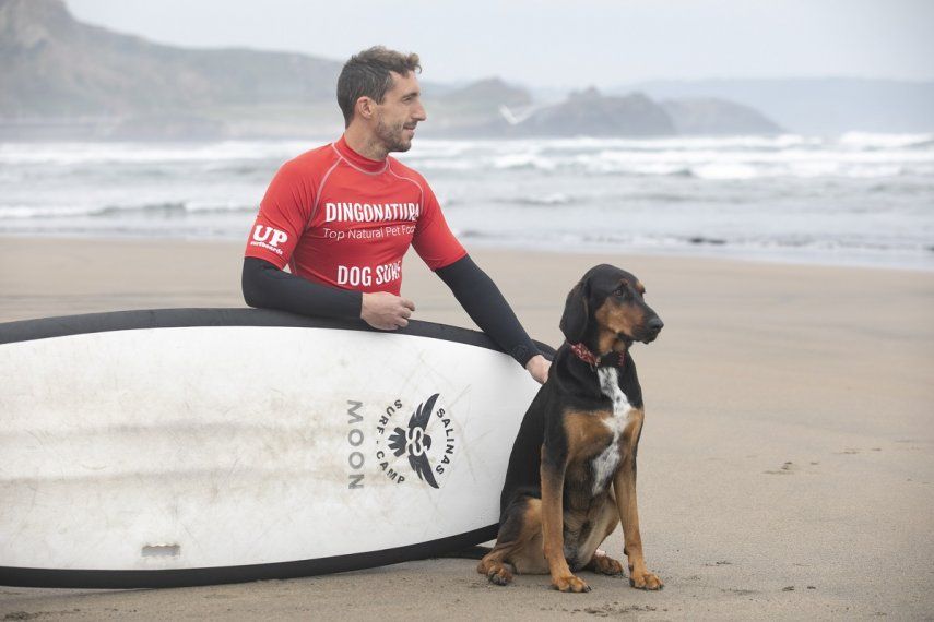 Un surfista participa con su perro en el II Campeonato Europeo de Surf para Perros Dingonatura Surf Dog, en la playa de Salinas, a 21 de mayo de 2023, en Castrillón, Asturias (España).&nbsp;&nbsp;
