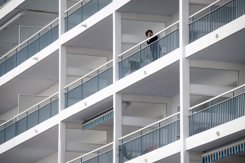 Una mujer observa hacia la calle desde su balc&oacute;n en La Baule, en el oeste de Francia, el 27 de marzo de 2020, mientras el pa&iacute;s est&aacute; cerrado para detener la propagaci&oacute;n de la pandemia de Covid-19 causada por el nuevo coronavirus.