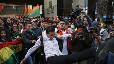 Partidarios del candidato opositor y expresidente Carlos Mesa retienen a un compa&ntilde;ero que intenta patear a los simpatizantes del presidente boliviano Evo Morales, que se postul&oacute; a un cuarto per&iacute;odo, frente al Tribunal Supremo Electoral, en La Paz, Bolivia, el lunes 21 de octubre de 2019.