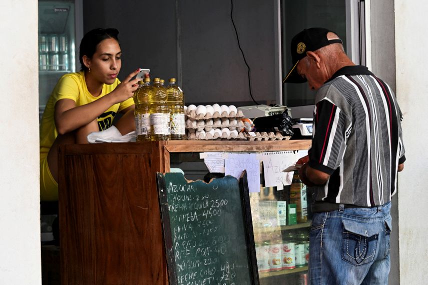 Comprar comida básica es un lujo en la isla. Hombre busca el dinero frente a una tienda de alimentos.