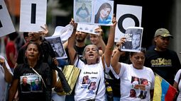 Estudiantes y familiares de presos políticos exhiben retratos de los reclusos durante una protesta para exigir su liberación frente a la Universidad Central de Venezuela (UCV) en Caracas, el 13 de mayo de 2026. Estudiantes universitarios y sus familias bloquearon la principal avenida de Caracas ese día para protestar por la desaparición forzada de unos 50 presos políticos en Venezuela y la muerte bajo custodia de aproximadamente 20 detenidos en la última década.