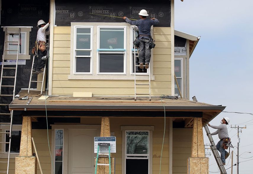 Empleados de una empresa de construcción de un dueño latino trabajan en una nueva propiedad.