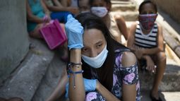 Una mujer, con mascarilla y guantes para protegerse del coronavirus, espera en el exterior de un comedor ben&eacute;fico gestionado por monjas para recibir algo de comida, en la barriada de Petare, en Caracas, Venezuela, el 30 de abril de 2020.&nbsp;