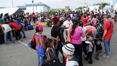 Venezolanos que emigran de su país hacen filas mientras esperan para ingresar a Perú.