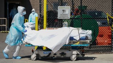 Personal médico traslada los cuerpos a un camión de refrigeración que sirve como depósito temporal de cadáveres en el Hospital Wyckoff en  Brooklyn, Nueva York, el 6 de abril de 2020.