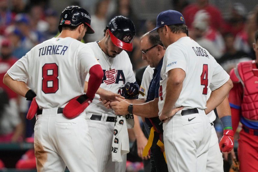 Nolan Arenado, de Estados Unidos, es revisado por un asistente del equipo después de recibir un pelotazo en la mano por un lanzamiento en la quinta entrada del partido del Clásico Mundial de béisbol entre Estados Unidos y Cuba, el domingo 19 de marzo de 2023, en Miami.&nbsp;