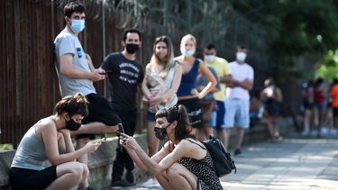 Personas esperan distanciadas socialmente fuera del Parque Centenario para hacerse la prueba gratuita de COVID-19 en Buenos Aires, Argentina, el viernes 31 de diciembre de 2021.