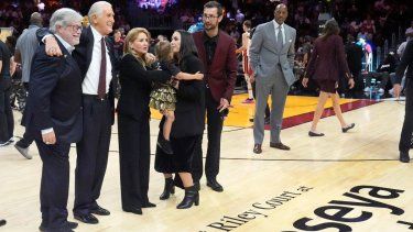 De izquierda a derecha, el socio director general del Heat de Miami, Micky Arison; el presidente del equipo Pat Riley y la familia de este último participan en una ceremonia el miércoles 23 de octubre de 2024.