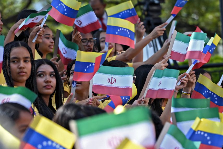 Jóvenes ondean banderas de&nbsp; e Irán durante la llegada del presidente iraní Ebrahim Raisi al palacio presidencial de Miraflores, en Caracas, el 12 de junio de 2023.&nbsp;